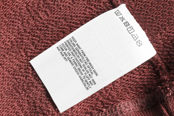 Zorg Kleding Label Rood Textiel Synthetische Achtergrond Closeup — Stockfoto