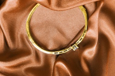 Saten üzerinde altın bilezik