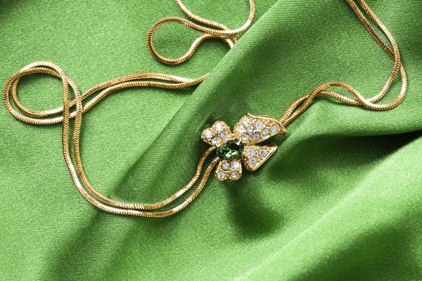 Necklace on green satin — 스톡 사진