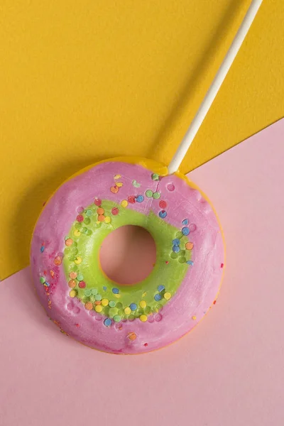 Πολύχρωμο Γλειφιτζούρι Σχήμα Ντόνατ Ροζ Και Κίτρινο Φόντο Χαρτιού — Φωτογραφία Αρχείου