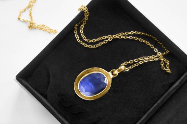 Siyah mücevher kutusunda altın zincirli klasik safir kolye.