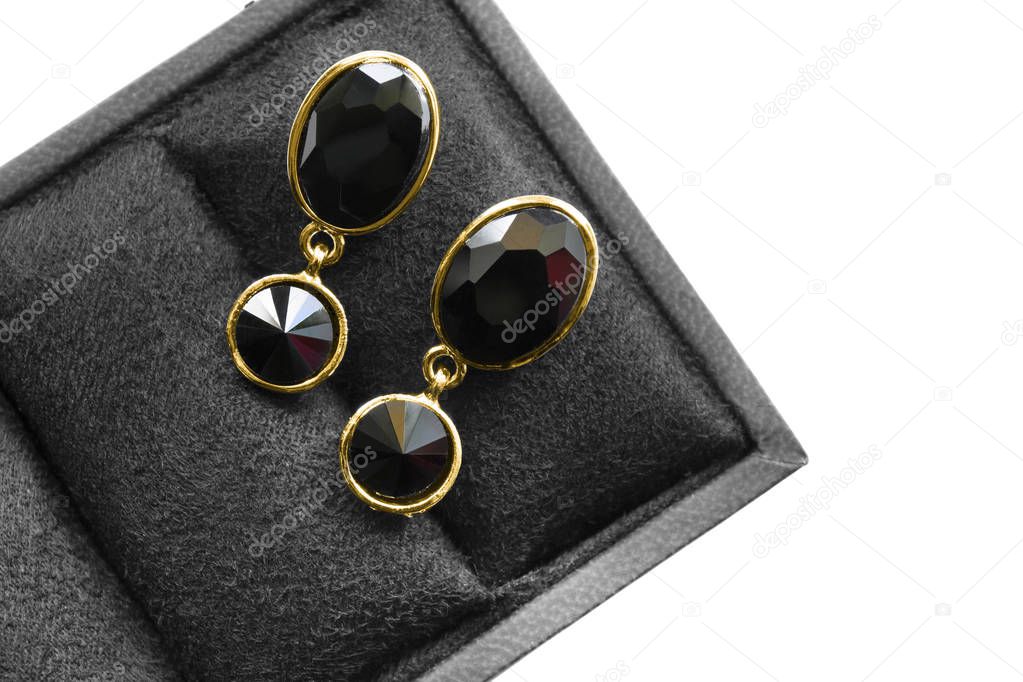 Elegant black onyx gold earrings in jewel box on white background