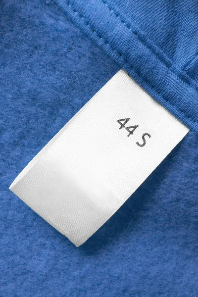 Etiqueta Ropa Tamaño Pequeño Sobre Fondo Textil Azul Primer Plano —  Fotos de Stock