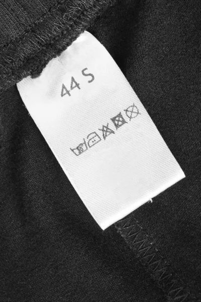 Größe Und Pflegebekleidung Etikett Auf Schwarzem Textilhintergrund — Stockfoto