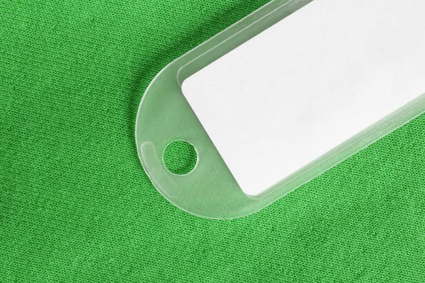 Etiqueta Plástico Blanco Sobre Fondo Verde Punto Cerca —  Fotos de Stock