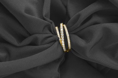 Elmaslı altın yüzük siyah ipekli yakın plan.