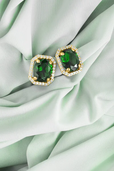 美丽的翡翠耳环 镶嵌着钻石 镶嵌在绿丝上 免版税图库图片