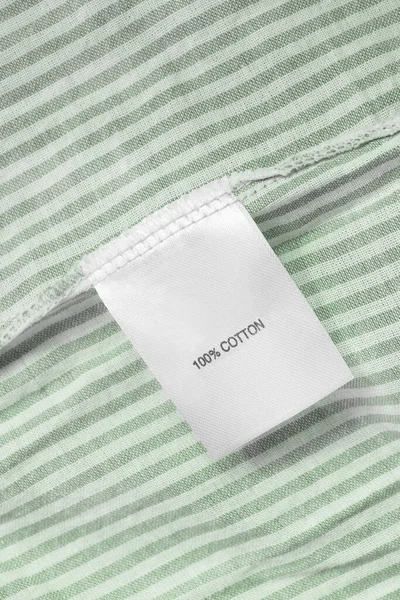 Ruházat Címkéjén 100 Pamut Van Zöld Csíkos Textil Háttérrel — Stock Fotó