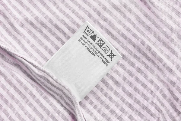 Etiqueta Ropa Cuidado Sobre Fondo Textil Rayas Rosa — Foto de Stock