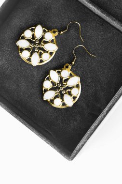 Siyah mücevher kutusuna oyulmuş altın rengi küpeler.