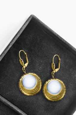 Kaliteli altın işlemeli küpeler mücevher kutusuna yakın plan.