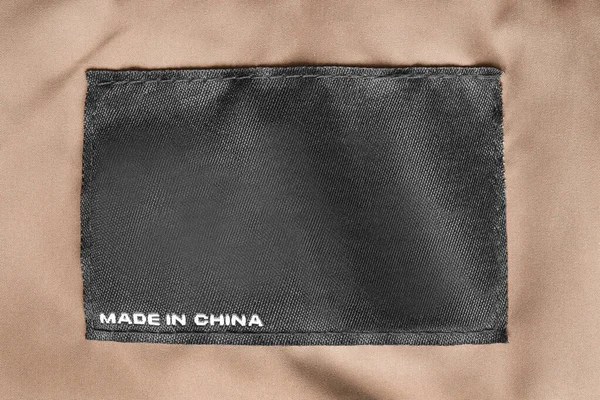 Etiqueta Ropa Dice Hecho China Sobre Fondo Textil Marrón Primer —  Fotos de Stock