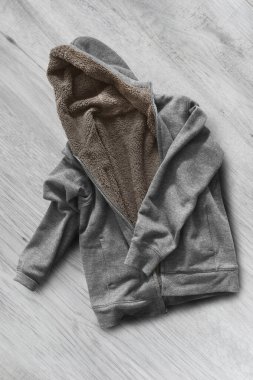 Beyaz ahşap arka planda katlanmış gri spor ceket.