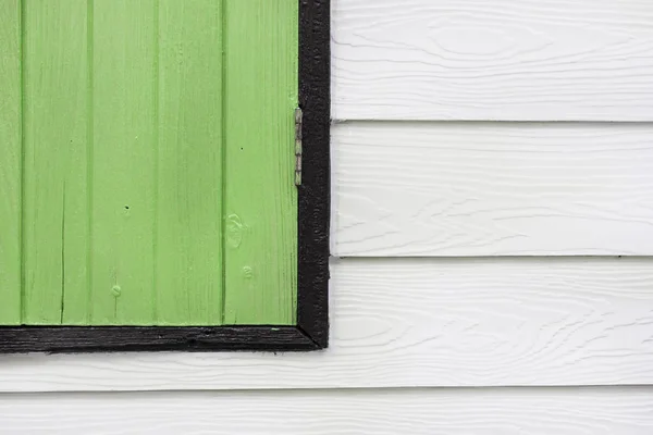 房屋中白色木墙上的绿色木窗拐角处. — 图库照片