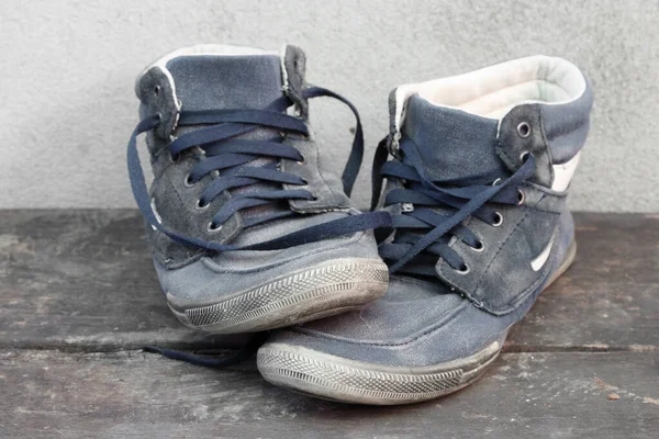 Usado zapatillas viejas en el suelo de madera . —  Fotos de Stock
