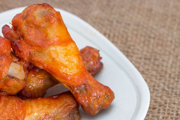 Alitas de pollo en plato en saco marrón. —  Fotos de Stock