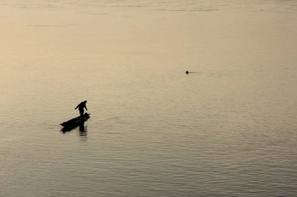 Silhouette del pescatore in una barca . — Foto Stock