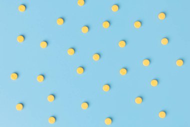 Mavi arka planda, kopyalama alanı olan sarı ilaç..