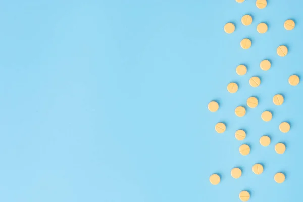 Gelbe Medizinische Pillen Auf Blauem Hintergrund Mit Kopierraum — Stockfoto