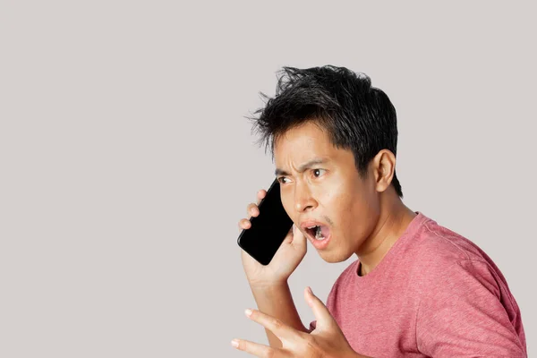 Młody Człowiek Rozmawiający Przez Telefon Zszokowany Zaskoczony Twarzą Szarym Tle — Zdjęcie stockowe