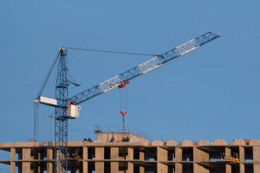 Mavi gökyüzüne karşı vinç ve inşaat alanı