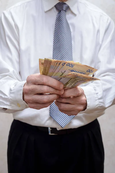 Uomo d'affari, o politico, contando una mazzetta di banconote grivna — Foto Stock