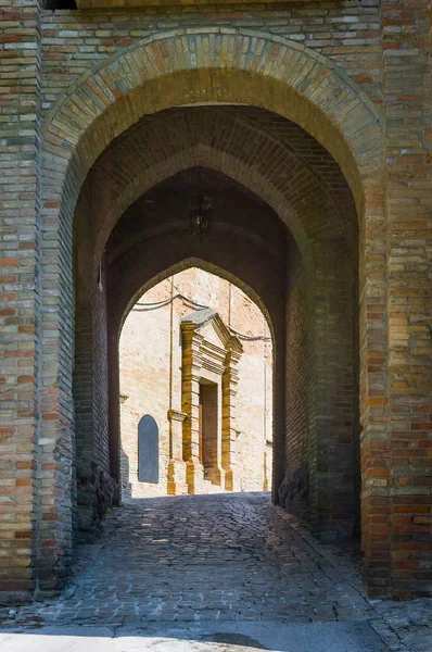 Bakstenen boog in Saludecio, met kerk — Stockfoto