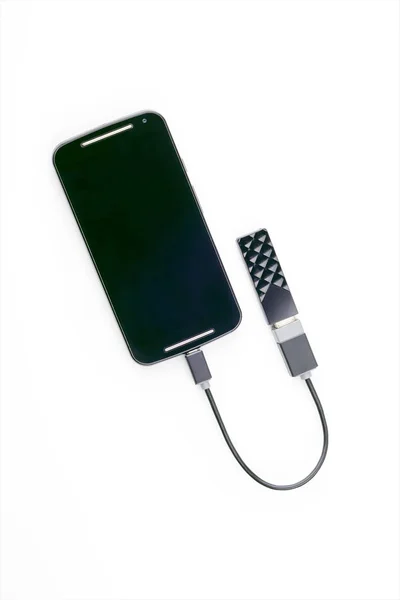 Смартфон подключен к USB-ключу с помощью OTG-кабеля — стоковое фото