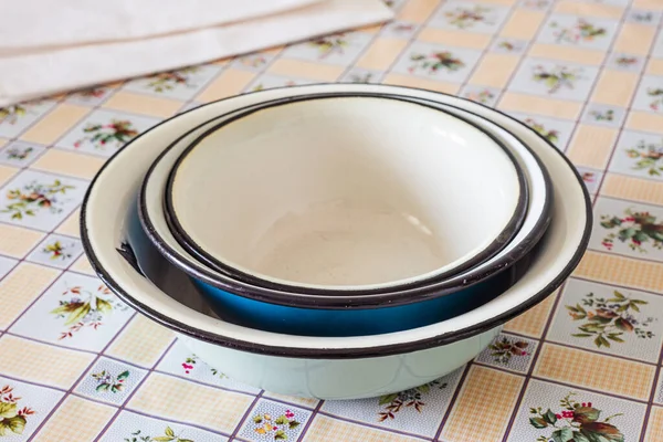厨房桌子上堆满了陈腐的搪瓷盘或碗 — 图库照片