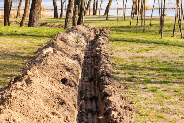 Boru Döşemek Için Toprağa Bir Siper Tüpler Parkta Ağaçların Altında — Stok fotoğraf