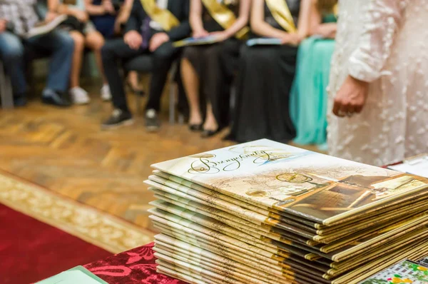 モスクワ ロシア 学校の卒業生のための紙の外交のスタックは 学校に座っている子供たちの背景にテーブルの上にあります ストック写真