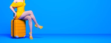 Açık yaz eteği bavul tekerleklerinde oturur. Kadın bacakları arka plan boyası. Kadın stüdyo fotoğrafı. Kavramsal moda sanatı.