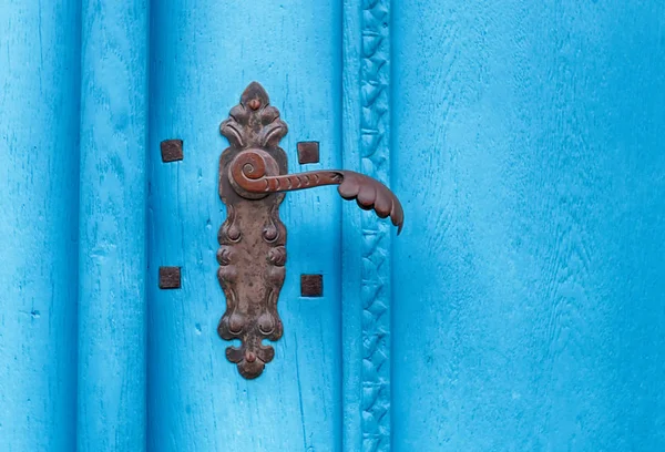 Iron door handle on a historical blue door