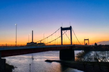 Almanya 'da Duisburg Ruhrort' ta eski bir köprünün üzerinde gün doğumu