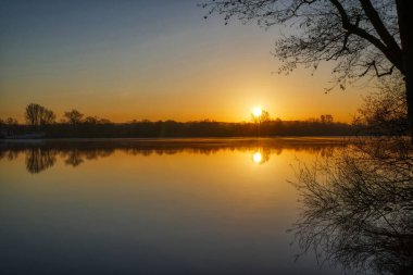 Almanya, Duisburg 'daki göl bölgesinde sabah ve güneş doğuyor.