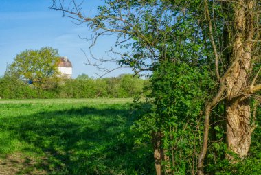 Almanya 'da Hohenbudberg' de çayır, köy ve su kulesi.
