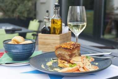 Kızarmış domuz eti, beyaz şarapla servis edilir.