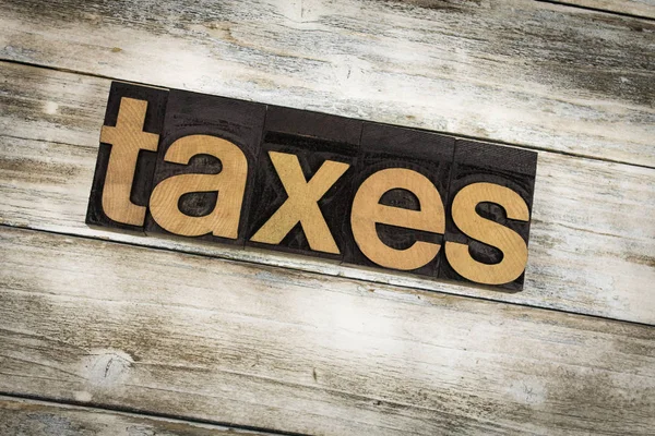 Impostos Letterpress Palavra sobre fundo de madeira — Fotografia de Stock