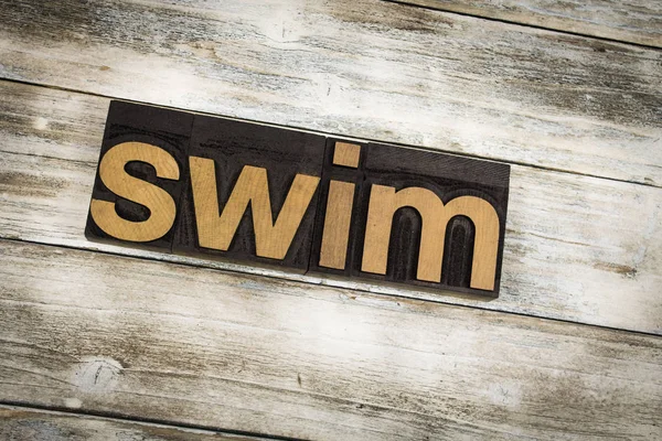 Swim Letterpress Word su sfondo di legno — Foto Stock