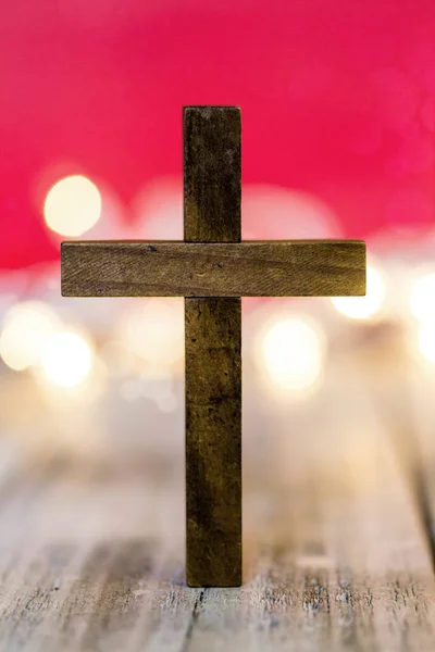 Santa Cruz de madeira cristã em um fundo vermelho abstrato — Fotografia de Stock