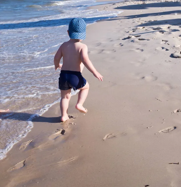 Mały Chłopiec Biegnie Wzdłuż Plaży Zostawia Ślady Stóp Piasku — Zdjęcie stockowe