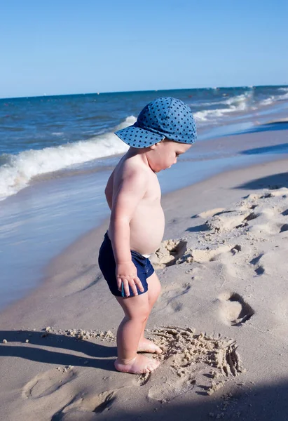 Mały Chłopiec Stoi Plaży Zostawia Ślady Stóp Piasku — Zdjęcie stockowe