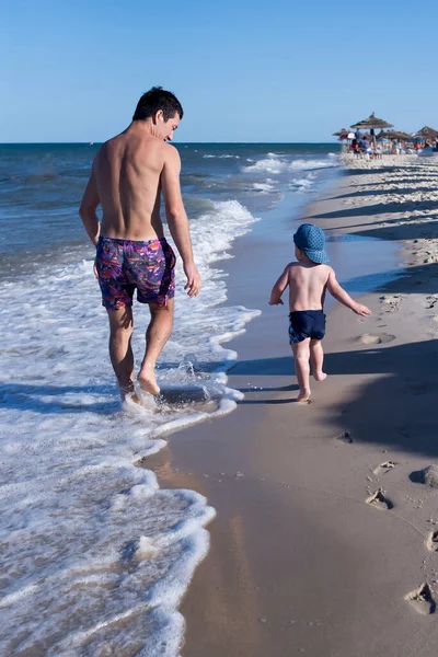 Ojciec Syn Biegną Wzdłuż Plaży Wzdłuż Piasku — Zdjęcie stockowe