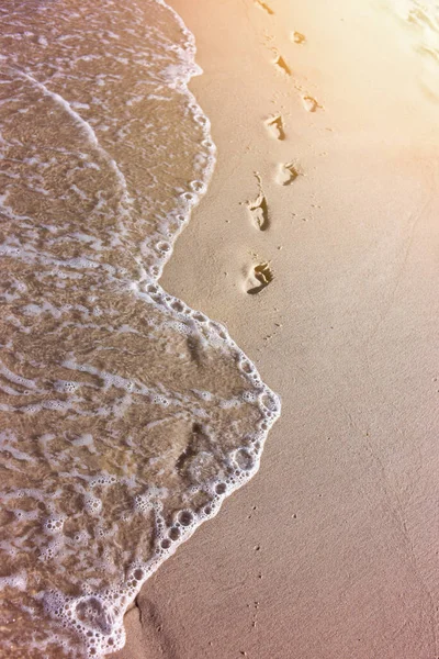 孩子们在海上沙滩上的脚印 — 图库照片