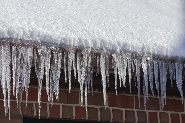 Ice icicles hanging from a roof gutter