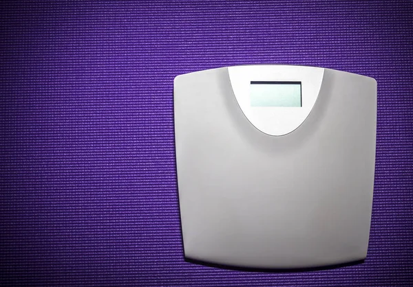 Digital weight scale on purple carpet — Stock Photo, Image