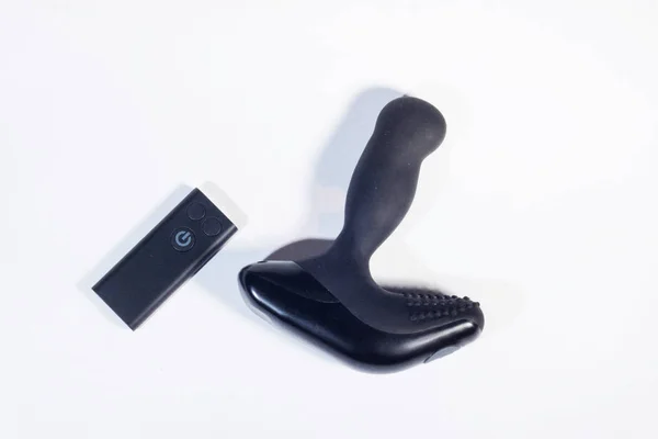 机械振动肛门插头与遥控器在白色背景 顶部视图 性爱游戏 前列腺按摩 图库图片