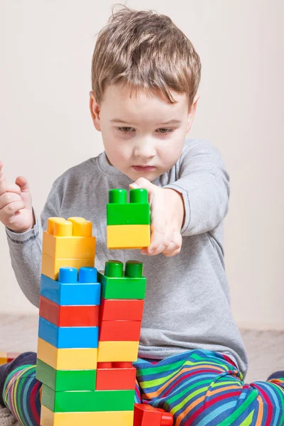 Spelen van kleine jongen met gekleurde blokjes — Stockfoto