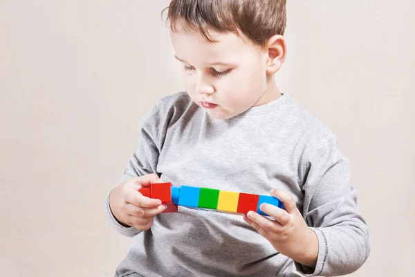 Spielender kleiner Junge mit farbigen Würfeln — Stockfoto