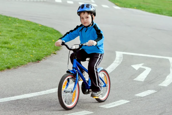 Niño en una bicicleta en la carretera de asfalto en el parque infantil de tráfico — Foto de Stock